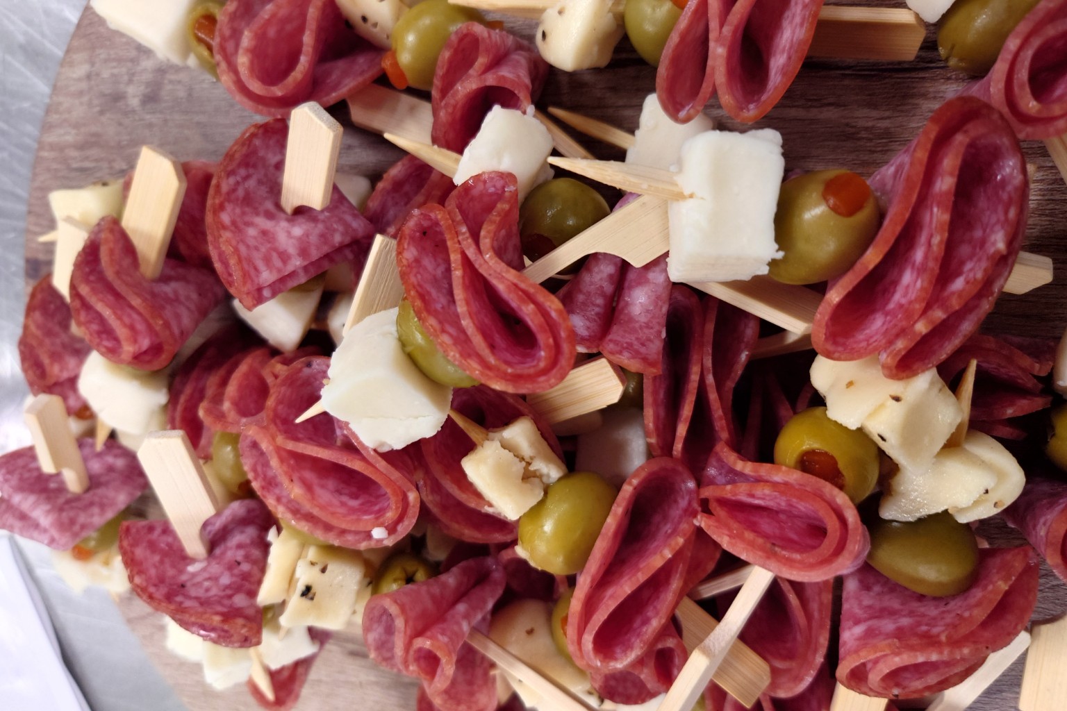 Salami, cheese and olive skewers arranged on a board