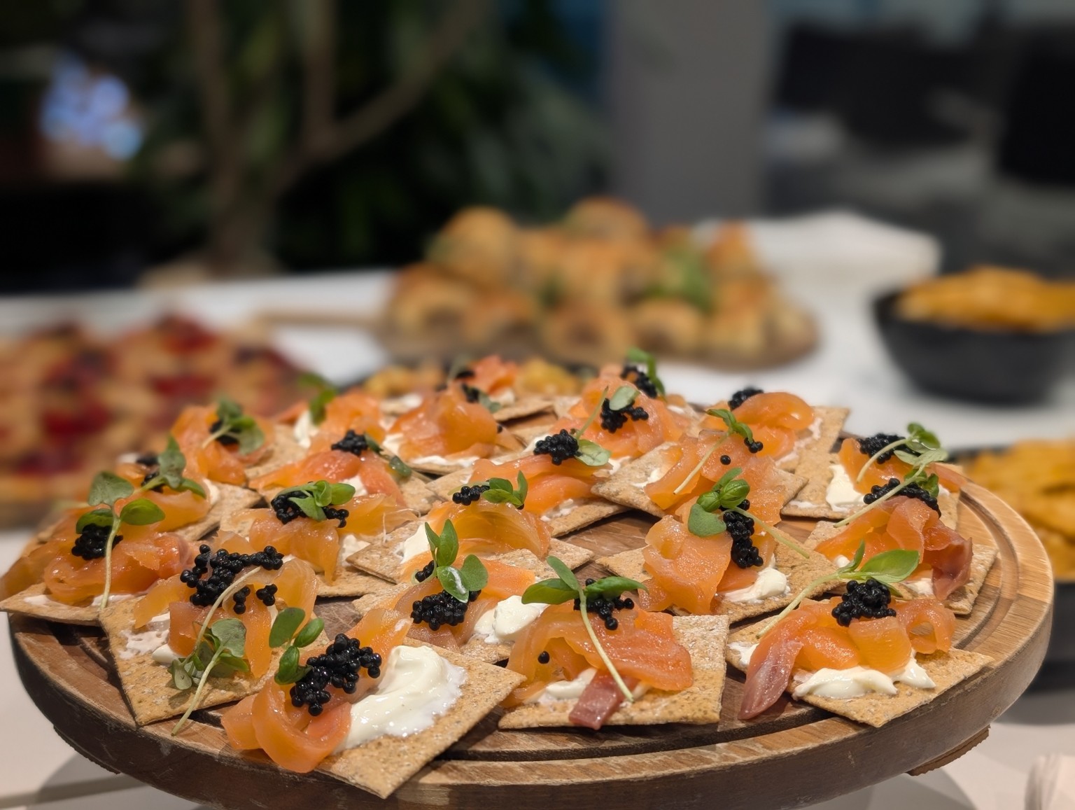 Smoked salmon canapés arranged on a wooden serving board
